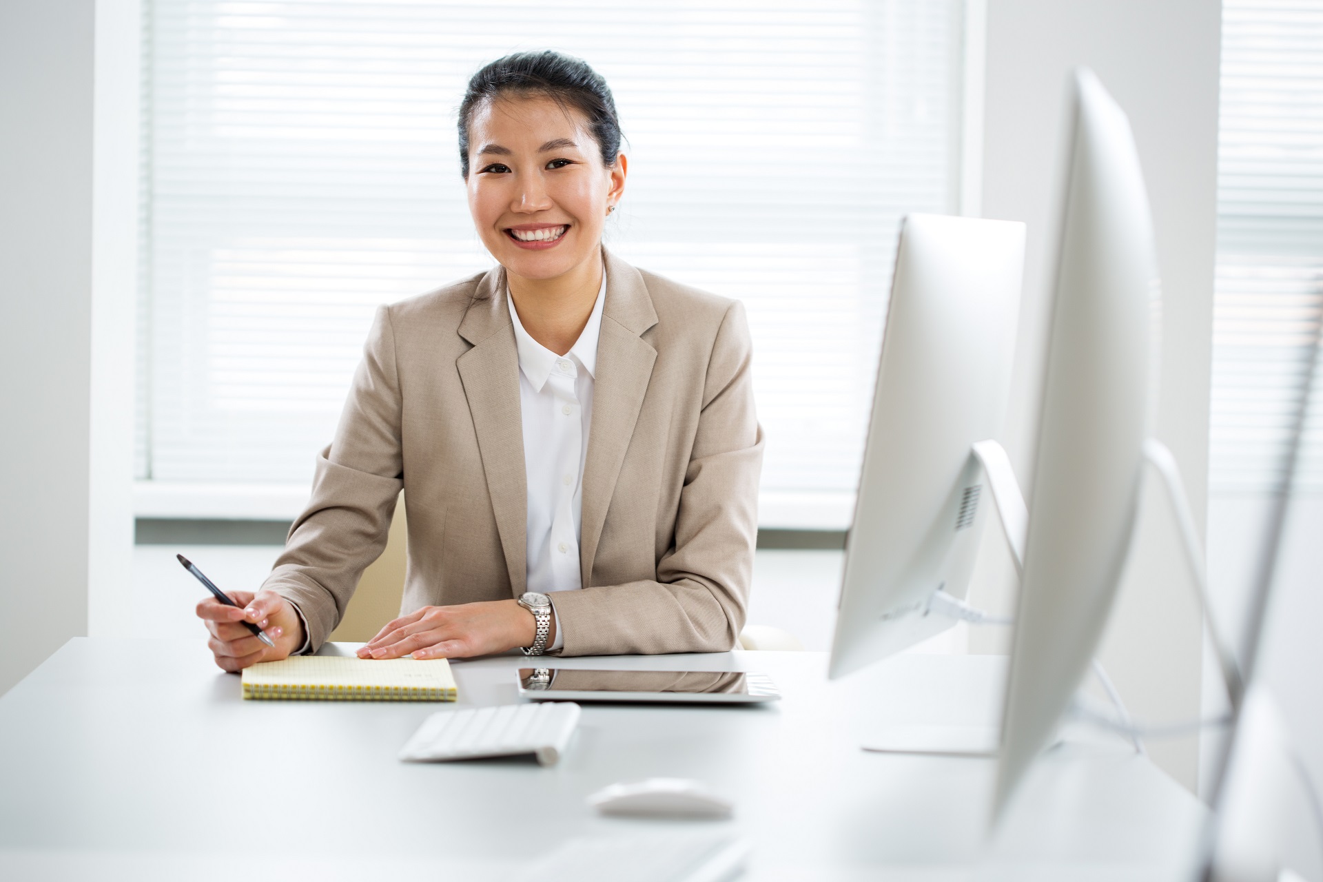 Asian business woman smiling at camera in an office Asian business woman smiling at camera in an office